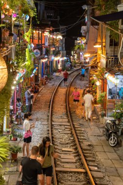 Hanoi, Vietnam - 08 Mayıs 2023: Hanoi Eski Mahallesi 'nin dar bir sokağından geçen tren görüntüsü. Turistler trenin resimlerini çekiyorlar. Hanoi Tren Sokağı popüler bir eğlencedir..