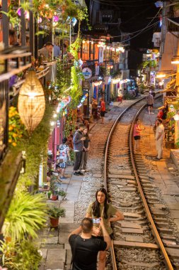 Hanoi, Vietnam - 08 Mayıs 2023: Hanoi Eski Mahallesi 'nin dar bir sokağından geçen tren görüntüsü. Turistler trenin resimlerini çekiyorlar. Hanoi Tren Sokağı popüler bir eğlencedir..