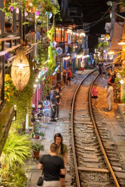 Hanoi, Vietnam - 08 Mayıs 2023: Hanoi Eski Mahallesi 'nin dar bir sokağından geçen tren görüntüsü. Turistler trenin resimlerini çekiyorlar. Hanoi Tren Sokağı popüler bir eğlencedir..
