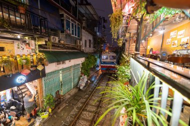 Hanoi, Vietnam - 08 Mayıs 2023: Hanoi Eski Mahallesi 'nin dar bir sokağından geçen tren görüntüsü. Turistler trenin resimlerini çekiyorlar. Hanoi Tren Sokağı popüler bir eğlencedir..