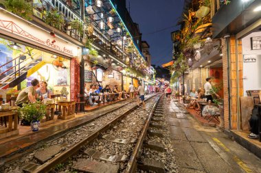 Hanoi, Vietnam - 08 Mayıs 2023: Hanoi Eski Mahallesi 'nin dar bir sokağından geçen tren görüntüsü. Turistler trenin resimlerini çekiyorlar. Hanoi Tren Sokağı popüler bir eğlencedir..