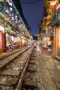 Hanoi, Vietnam - 08 Mayıs 2023: Hanoi Eski Mahallesi 'nin dar bir sokağından geçen tren görüntüsü. Turistler trenin resimlerini çekiyorlar. Hanoi Tren Sokağı popüler bir eğlencedir..