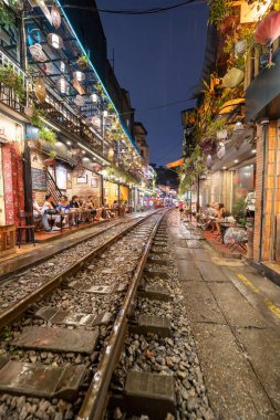 Hanoi, Vietnam - 08 Mayıs 2023: Hanoi Eski Mahallesi 'nin dar bir sokağından geçen tren görüntüsü. Turistler trenin resimlerini çekiyorlar. Hanoi Tren Sokağı popüler bir eğlencedir..