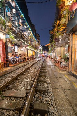 Hanoi, Vietnam - 08 Mayıs 2023: Hanoi Eski Mahallesi 'nin dar bir sokağından geçen tren görüntüsü. Turistler trenin resimlerini çekiyorlar. Hanoi Tren Sokağı popüler bir eğlencedir..