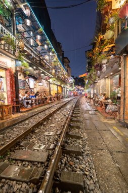 Hanoi, Vietnam - 08 Mayıs 2023: Hanoi Eski Mahallesi 'nin dar bir sokağından geçen tren görüntüsü. Turistler trenin resimlerini çekiyorlar. Hanoi Tren Sokağı popüler bir eğlencedir..