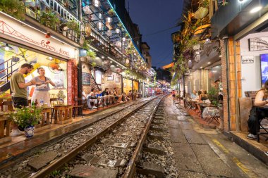 Hanoi, Vietnam - 08 Mayıs 2023: Hanoi Eski Mahallesi 'nin dar bir sokağından geçen tren görüntüsü. Turistler trenin resimlerini çekiyorlar. Hanoi Tren Sokağı popüler bir eğlencedir..