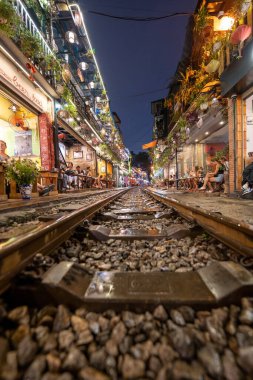 Hanoi, Vietnam - 08 Mayıs 2023: Hanoi Eski Mahallesi 'nin dar bir sokağından geçen tren görüntüsü. Turistler trenin resimlerini çekiyorlar. Hanoi Tren Sokağı popüler bir eğlencedir..