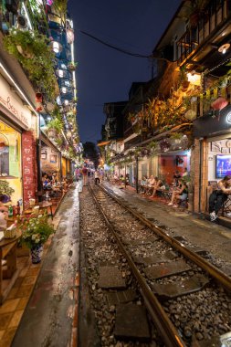 Hanoi, Vietnam - 08 Mayıs 2023: Hanoi Eski Mahallesi 'nin dar bir sokağından geçen tren görüntüsü. Turistler trenin resimlerini çekiyorlar. Hanoi Tren Sokağı popüler bir eğlencedir..
