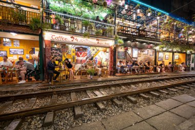 Hanoi, Vietnam - 08 Mayıs 2023: Hanoi Eski Mahallesi 'nin dar bir sokağından geçen tren görüntüsü. Turistler trenin resimlerini çekiyorlar. Hanoi Tren Sokağı popüler bir eğlencedir..