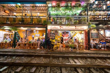 Hanoi, Vietnam - 08 Mayıs 2023: Hanoi Eski Mahallesi 'nin dar bir sokağından geçen tren görüntüsü. Turistler trenin resimlerini çekiyorlar. Hanoi Tren Sokağı popüler bir eğlencedir..