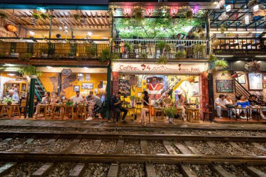 Hanoi, Vietnam - 08 Mayıs 2023: Hanoi Eski Mahallesi 'nin dar bir sokağından geçen tren görüntüsü. Turistler trenin resimlerini çekiyorlar. Hanoi Tren Sokağı popüler bir eğlencedir..