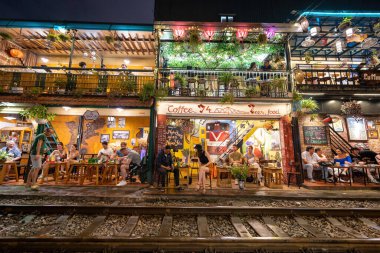 Hanoi, Vietnam - 08 Mayıs 2023: Hanoi Eski Mahallesi 'nin dar bir sokağından geçen tren görüntüsü. Turistler trenin resimlerini çekiyorlar. Hanoi Tren Sokağı popüler bir eğlencedir..
