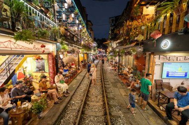 Hanoi, Vietnam - 08 Mayıs 2023: Hanoi Eski Mahallesi 'nin dar bir sokağından geçen tren görüntüsü. Turistler trenin resimlerini çekiyorlar. Hanoi Tren Sokağı popüler bir eğlencedir..