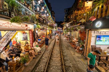 Hanoi, Vietnam - 08 Mayıs 2023: Hanoi Eski Mahallesi 'nin dar bir sokağından geçen tren görüntüsü. Turistler trenin resimlerini çekiyorlar. Hanoi Tren Sokağı popüler bir eğlencedir..