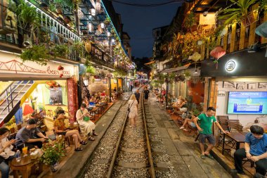 Hanoi, Vietnam - 08 Mayıs 2023: Hanoi Eski Mahallesi 'nin dar bir sokağından geçen tren görüntüsü. Turistler trenin resimlerini çekiyorlar. Hanoi Tren Sokağı popüler bir eğlencedir..