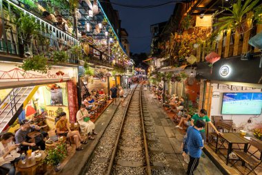 Hanoi, Vietnam - 08 Mayıs 2023: Hanoi Eski Mahallesi 'nin dar bir sokağından geçen tren görüntüsü. Turistler trenin resimlerini çekiyorlar. Hanoi Tren Sokağı popüler bir eğlencedir..