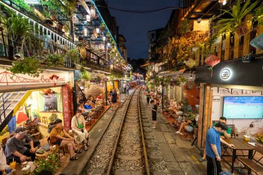 Hanoi, Vietnam - 08 Mayıs 2023: Hanoi Eski Mahallesi 'nin dar bir sokağından geçen tren görüntüsü. Turistler trenin resimlerini çekiyorlar. Hanoi Tren Sokağı popüler bir eğlencedir..