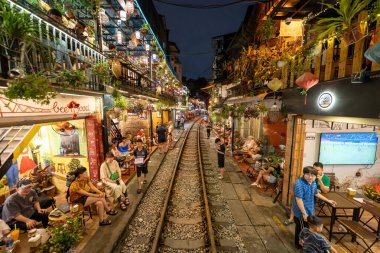 Hanoi, Vietnam - 08 Mayıs 2023: Hanoi Eski Mahallesi 'nin dar bir sokağından geçen tren görüntüsü. Turistler trenin resimlerini çekiyorlar. Hanoi Tren Sokağı popüler bir eğlencedir..