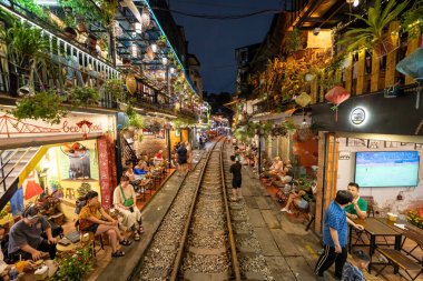 Hanoi, Vietnam - 08 Mayıs 2023: Hanoi Eski Mahallesi 'nin dar bir sokağından geçen tren görüntüsü. Turistler trenin resimlerini çekiyorlar. Hanoi Tren Sokağı popüler bir eğlencedir..