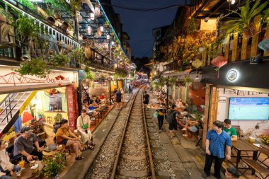 Hanoi, Vietnam - 08 Mayıs 2023: Hanoi Eski Mahallesi 'nin dar bir sokağından geçen tren görüntüsü. Turistler trenin resimlerini çekiyorlar. Hanoi Tren Sokağı popüler bir eğlencedir..