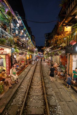 Hanoi, Vietnam - 08 Mayıs 2023: Hanoi Eski Mahallesi 'nin dar bir sokağından geçen tren görüntüsü. Turistler trenin resimlerini çekiyorlar. Hanoi Tren Sokağı popüler bir eğlencedir..