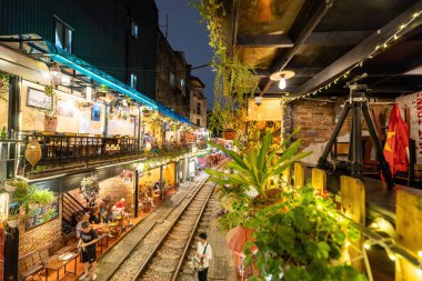 Hanoi, Vietnam - 08 Mayıs 2023: Hanoi Eski Mahallesi 'nin dar bir sokağından geçen tren görüntüsü. Turistler trenin resimlerini çekiyorlar. Hanoi Tren Sokağı popüler bir eğlencedir..