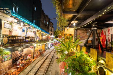 Hanoi, Vietnam - 08 Mayıs 2023: Hanoi Eski Mahallesi 'nin dar bir sokağından geçen tren görüntüsü. Turistler trenin resimlerini çekiyorlar. Hanoi Tren Sokağı popüler bir eğlencedir..