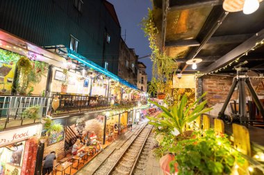 Hanoi, Vietnam - 08 Mayıs 2023: Hanoi Eski Mahallesi 'nin dar bir sokağından geçen tren görüntüsü. Turistler trenin resimlerini çekiyorlar. Hanoi Tren Sokağı popüler bir eğlencedir..