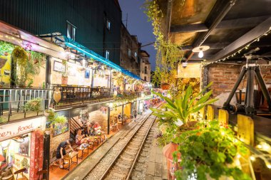 Hanoi, Vietnam - 08 Mayıs 2023: Hanoi Eski Mahallesi 'nin dar bir sokağından geçen tren görüntüsü. Turistler trenin resimlerini çekiyorlar. Hanoi Tren Sokağı popüler bir eğlencedir..