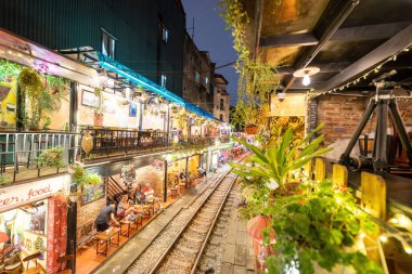 Hanoi, Vietnam - 08 Mayıs 2023: Hanoi Eski Mahallesi 'nin dar bir sokağından geçen tren görüntüsü. Turistler trenin resimlerini çekiyorlar. Hanoi Tren Sokağı popüler bir eğlencedir..