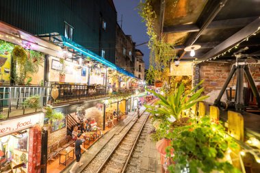 Hanoi, Vietnam - 08 Mayıs 2023: Hanoi Eski Mahallesi 'nin dar bir sokağından geçen tren görüntüsü. Turistler trenin resimlerini çekiyorlar. Hanoi Tren Sokağı popüler bir eğlencedir..