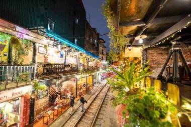 Hanoi, Vietnam - 08 Mayıs 2023: Hanoi Eski Mahallesi 'nin dar bir sokağından geçen tren görüntüsü. Turistler trenin resimlerini çekiyorlar. Hanoi Tren Sokağı popüler bir eğlencedir..