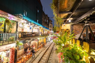 Hanoi, Vietnam - 08 Mayıs 2023: Hanoi Eski Mahallesi 'nin dar bir sokağından geçen tren görüntüsü. Turistler trenin resimlerini çekiyorlar. Hanoi Tren Sokağı popüler bir eğlencedir..