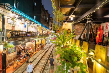 Hanoi, Vietnam - 08 Mayıs 2023: Hanoi Eski Mahallesi 'nin dar bir sokağından geçen tren görüntüsü. Turistler trenin resimlerini çekiyorlar. Hanoi Tren Sokağı popüler bir eğlencedir..