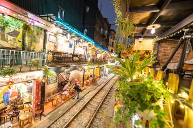 Hanoi, Vietnam - 08 Mayıs 2023: Hanoi Eski Mahallesi 'nin dar bir sokağından geçen tren görüntüsü. Turistler trenin resimlerini çekiyorlar. Hanoi Tren Sokağı popüler bir eğlencedir..
