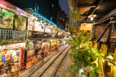 Hanoi, Vietnam - 08 Mayıs 2023: Hanoi Eski Mahallesi 'nin dar bir sokağından geçen tren görüntüsü. Turistler trenin resimlerini çekiyorlar. Hanoi Tren Sokağı popüler bir eğlencedir..