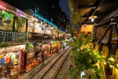 Hanoi, Vietnam - 08 Mayıs 2023: Hanoi Eski Mahallesi 'nin dar bir sokağından geçen tren görüntüsü. Turistler trenin resimlerini çekiyorlar. Hanoi Tren Sokağı popüler bir eğlencedir..