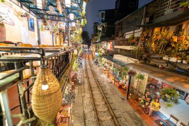 Hanoi, Vietnam - 08 Mayıs 2023: Hanoi Eski Mahallesi 'nin dar bir sokağından geçen tren görüntüsü. Turistler trenin resimlerini çekiyorlar. Hanoi Tren Sokağı popüler bir eğlencedir..