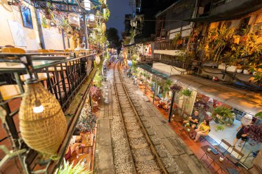 Hanoi, Vietnam - 08 Mayıs 2023: Hanoi Eski Mahallesi 'nin dar bir sokağından geçen tren görüntüsü. Turistler trenin resimlerini çekiyorlar. Hanoi Tren Sokağı popüler bir eğlencedir..