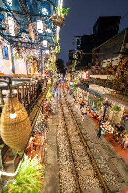 Hanoi, Vietnam - 08 Mayıs 2023: Hanoi Eski Mahallesi 'nin dar bir sokağından geçen tren görüntüsü. Turistler trenin resimlerini çekiyorlar. Hanoi Tren Sokağı popüler bir eğlencedir..