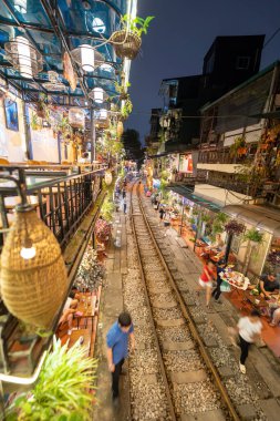 Hanoi, Vietnam - 08 Mayıs 2023: Hanoi Eski Mahallesi 'nin dar bir sokağından geçen tren görüntüsü. Turistler trenin resimlerini çekiyorlar. Hanoi Tren Sokağı popüler bir eğlencedir..