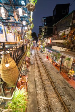 Hanoi, Vietnam - 08 Mayıs 2023: Hanoi Eski Mahallesi 'nin dar bir sokağından geçen tren görüntüsü. Turistler trenin resimlerini çekiyorlar. Hanoi Tren Sokağı popüler bir eğlencedir..