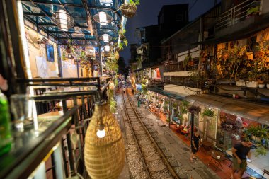 Hanoi, Vietnam - 08 Mayıs 2023: Hanoi Eski Mahallesi 'nin dar bir sokağından geçen tren görüntüsü. Turistler trenin resimlerini çekiyorlar. Hanoi Tren Sokağı popüler bir eğlencedir..