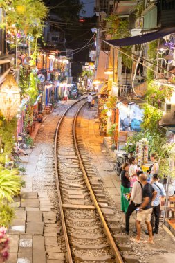 Hanoi, Vietnam - 08 Mayıs 2023: Hanoi Eski Mahallesi 'nin dar bir sokağından geçen tren görüntüsü. Turistler trenin resimlerini çekiyorlar. Hanoi Tren Sokağı popüler bir eğlencedir..