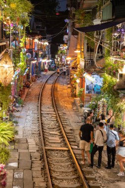Hanoi, Vietnam - 08 Mayıs 2023: Hanoi Eski Mahallesi 'nin dar bir sokağından geçen tren görüntüsü. Turistler trenin resimlerini çekiyorlar. Hanoi Tren Sokağı popüler bir eğlencedir..