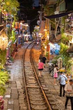 Hanoi, Vietnam - 08 Mayıs 2023: Hanoi Eski Mahallesi 'nin dar bir sokağından geçen tren görüntüsü. Turistler trenin resimlerini çekiyorlar. Hanoi Tren Sokağı popüler bir eğlencedir..