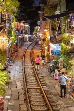Hanoi, Vietnam - 08 Mayıs 2023: Hanoi Eski Mahallesi 'nin dar bir sokağından geçen tren görüntüsü. Turistler trenin resimlerini çekiyorlar. Hanoi Tren Sokağı popüler bir eğlencedir..