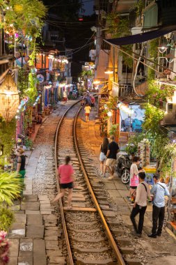 Hanoi, Vietnam - 08 Mayıs 2023: Hanoi Eski Mahallesi 'nin dar bir sokağından geçen tren görüntüsü. Turistler trenin resimlerini çekiyorlar. Hanoi Tren Sokağı popüler bir eğlencedir..