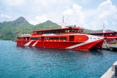 Con Dao Adası, Vietnam - 30 Nisan 2023: Vung Tau şehrinden Con Dao adasındaki Ben Dam limanına giden güzel mavi deniz, mavi gökyüzü dağı ve renkli teknelerin görüntüsü.