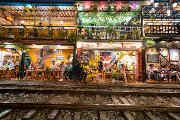 stock image Hanoi, Vietnam - 08 May 2023 : View of train passing through a narrow street of the Hanoi Old Quarter. Tourists taking pictures of hurtling train. The Hanoi Train Street is a popular attraction.